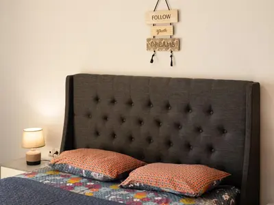 a bed with a black headboard and two pillows at Athens Airport Luxury Apartment in Spáta