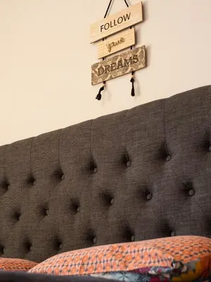 a headboard of a bed with books on the wall at Athens Airport Luxury Apartment in Spáta