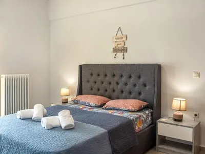 a bedroom with a bed with two towels on it at Athens Airport Luxury Apartment in Spáta
