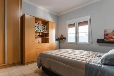 a bedroom with a bed and a dresser and a window at Sweet home in Athens