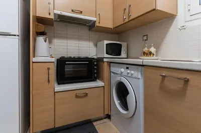 a kitchen with a washing machine and a microwave at Sweet home in Athens