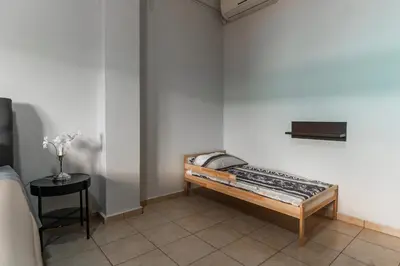 a bedroom with a bed and a side table at Sweet home in Athens