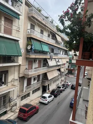 a street with cars parked in front of a building at Sweet home in Athens
