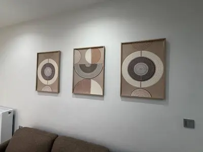 four pictures on a wall above a couch at Urban Comfort Apartment in Athens