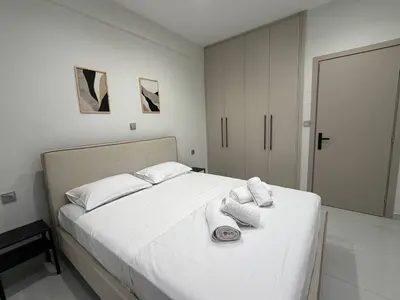 a bedroom with a white bed with towels on it at Urban Comfort Apartment in Athens