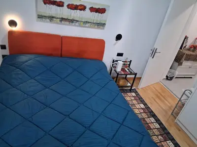 a bedroom with a blue bed with an orange headboard at B2 ACROPOLIs 2 in Athens