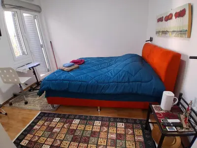 a bedroom with a bed with a blue comforter and a table at B2 ACROPOLIs 2 in Athens