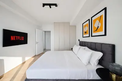 a bedroom with a white bed and a couch at Costa Elliniko Pool & Beach Sea View DA1 in Athens