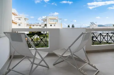 two chairs on a balcony with a view at La Suite by A&D Properties in Porto Rafti