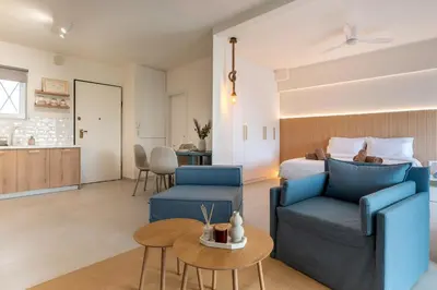a bedroom with a bed and a couch and a table at La Suite by A&D Properties in Porto Rafti