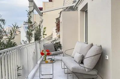 a balcony with a chair and a vase of flowers at Athenian Exclusive Penthouse in Athens