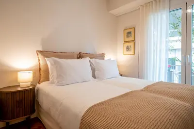 a bedroom with a large white bed with a window at Athenian Exclusive Penthouse in Athens