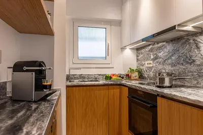 a kitchen with marble counter tops and a window at Athenian Exclusive Penthouse in Athens