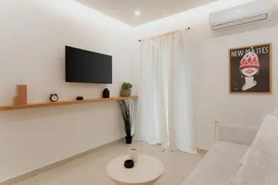a white living room with a tv and a couch at 1BR Designer Suite Homey Feel Near Metro in Athens