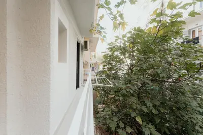 a white building with a tree on the side of it at 1BR Designer Suite Homey Feel Near Metro in Athens