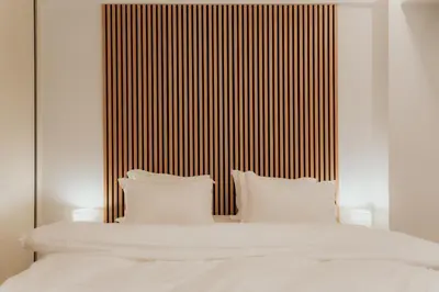 a white bed with white pillows and a striped headboard at 1BR Designer Suite Homey Feel Near Metro in Athens