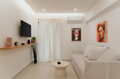 a white living room with a couch and a tv at 1BR Designer Suite Homey Feel Near Metro in Athens