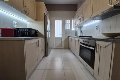 a large kitchen with white cabinets and a stove at Athens Riviera Alimos by Comfort Club in Athens