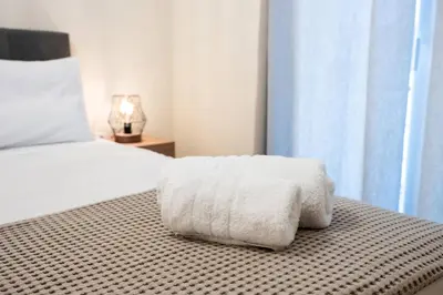 a white towel sitting on a bed in a bedroom at Athens Unity Apartment in Athens