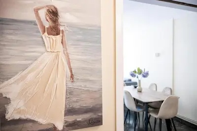 a painting of a woman in a white dress on a wall at Athens Unity Apartment in Athens