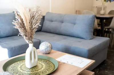a vase on a table in a living room with a couch at Athens Unity Apartment in Athens