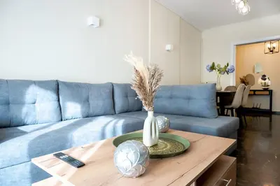 a living room with a blue couch and a table at Athens Unity Apartment in Athens