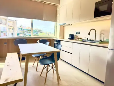 a kitchen with white cabinets and a table and chairs at Boutique City Apartment 3' Metro in Athens