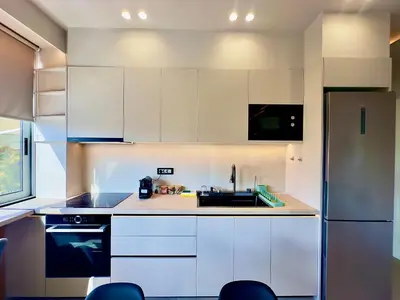 a kitchen with white cabinets and a sink and a refrigerator at Boutique City Apartment 3' Metro in Athens