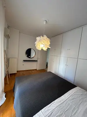 a bedroom with a bed and a chandelier at Elegant Flat Near Hospitals & Museums in Athens
