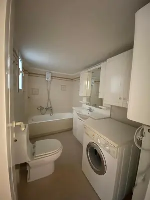 a bathroom with a toilet a sink and a washing machine at Elegant Flat Near Hospitals & Museums in Athens