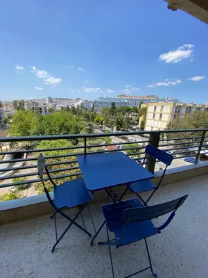 a blue table and two chairs on a balcony at Elegant Flat Near Hospitals & Museums in Athens