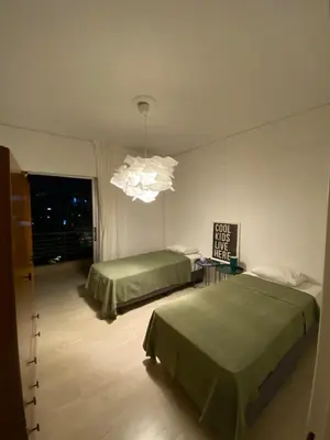 a bedroom with two beds and a chandelier at Elegant Flat Near Hospitals & Museums in Athens