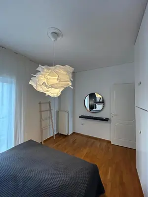 a bedroom with a bed and a round mirror at Elegant Flat Near Hospitals & Museums in Athens