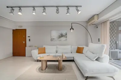 a living room with a white couch and a table at Coastal Serenity - Glyfada Central - Lampraki 6 by K&M in Athens