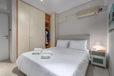 a bedroom with a large white bed with towels on it at Coastal Serenity - Glyfada Central - Lampraki 6 by K&M in Athens