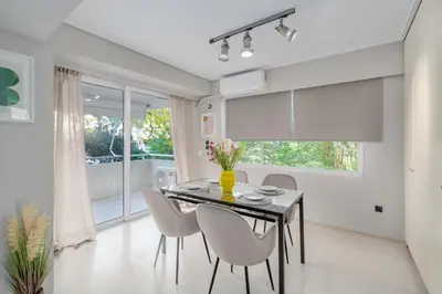 a dining room with a table and chairs and a window at Coastal Serenity - Glyfada Central - Lampraki 6 by K&M in Athens