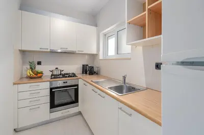 a white kitchen with white cabinets and a sink at Coastal Serenity - Glyfada Central - Lampraki 6 by K&M in Athens