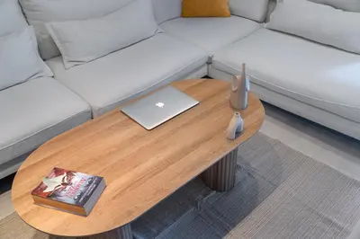 a coffee table in front of a couch with a laptop at Coastal Serenity - Glyfada Central - Lampraki 6 by K&M in Athens