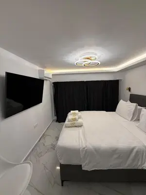 a bedroom with a large bed and a tv at City Center Lux Studio in Athens