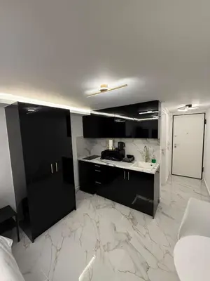a kitchen with black cabinets and a marble floor at City Center Lux Studio in Athens