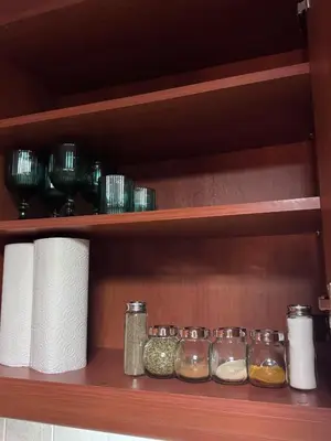a shelf with several glass jars and towels at Parmen APT in Piraeus