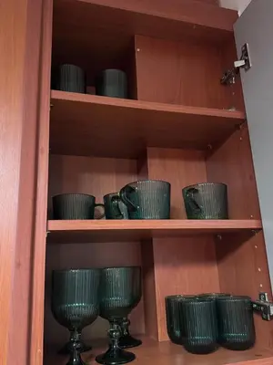 a wooden shelf with green glasses on it at Parmen APT in Piraeus