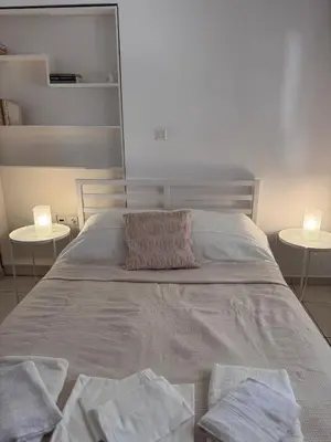 a bedroom with a large bed with two tables at Parmen APT in Piraeus