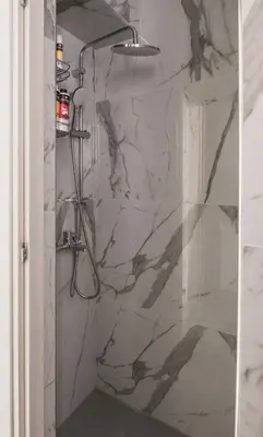 a bathroom with a shower with a marble wall at ANDIE Archaeological Museum in Athens