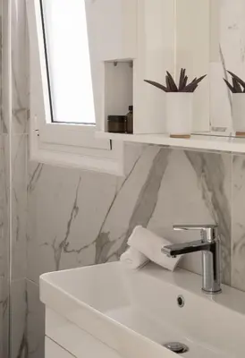 a white bathroom with a sink and a mirror at ANDIE Archaeological Museum in Athens