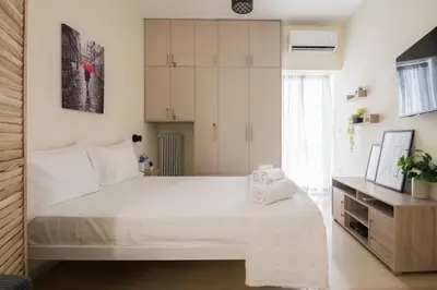 a bedroom with a large white bed and a window at ANDIE Kallithea Filaretou in Athens