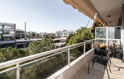a balcony with a table and a view of a city at Mia Homes - Athens Riviera at Voula Center in Athens