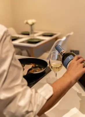 a person is pouring a glass of wine at Mia Homes - Athens Riviera at Voula Center in Athens