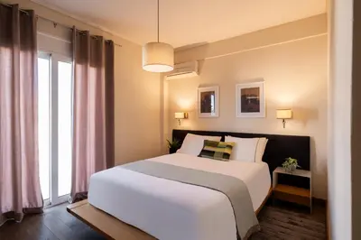 a bedroom with a white bed and a large window at Mia Homes - Athens Riviera at Voula Center in Athens