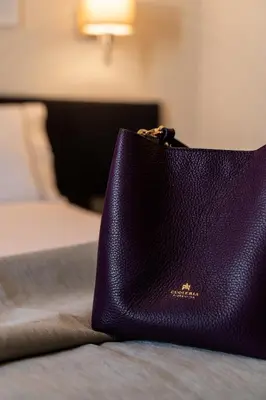 a purple purse sitting on top of a bed at Mia Homes - Athens Riviera at Voula Center in Athens